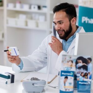 A pharmacist looking at medication while they speak to someone on the phone