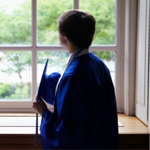 A new graduate looking out a window