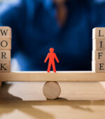 A paper cutout of a person balancing between work and life