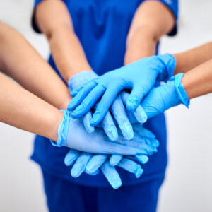 A group of medical professionals putting their hands together