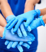 A group of medical professionals putting their hands together