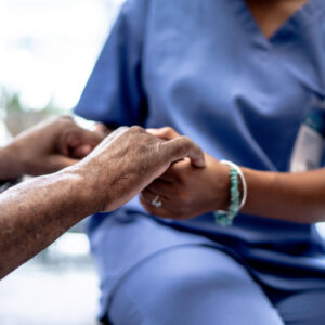 A nurse holding a patient's hand