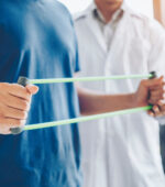 A physical therapist helping a person with a tension exercise