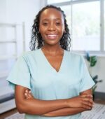 A medical worker poses and smiles for a photo