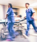 Emergency room professionals move a patient on a stretcher