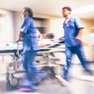 Emergency room professionals move a patient on a stretcher