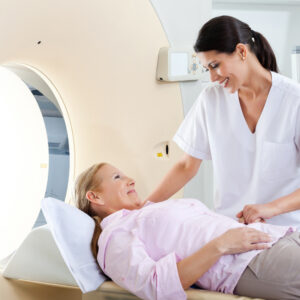 A medical professional helps a patient into an MRI machine