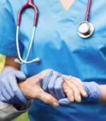 A nurse holding a patient's hand