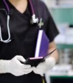 a nurse holding and scrolling through nursing apps on a smart phone